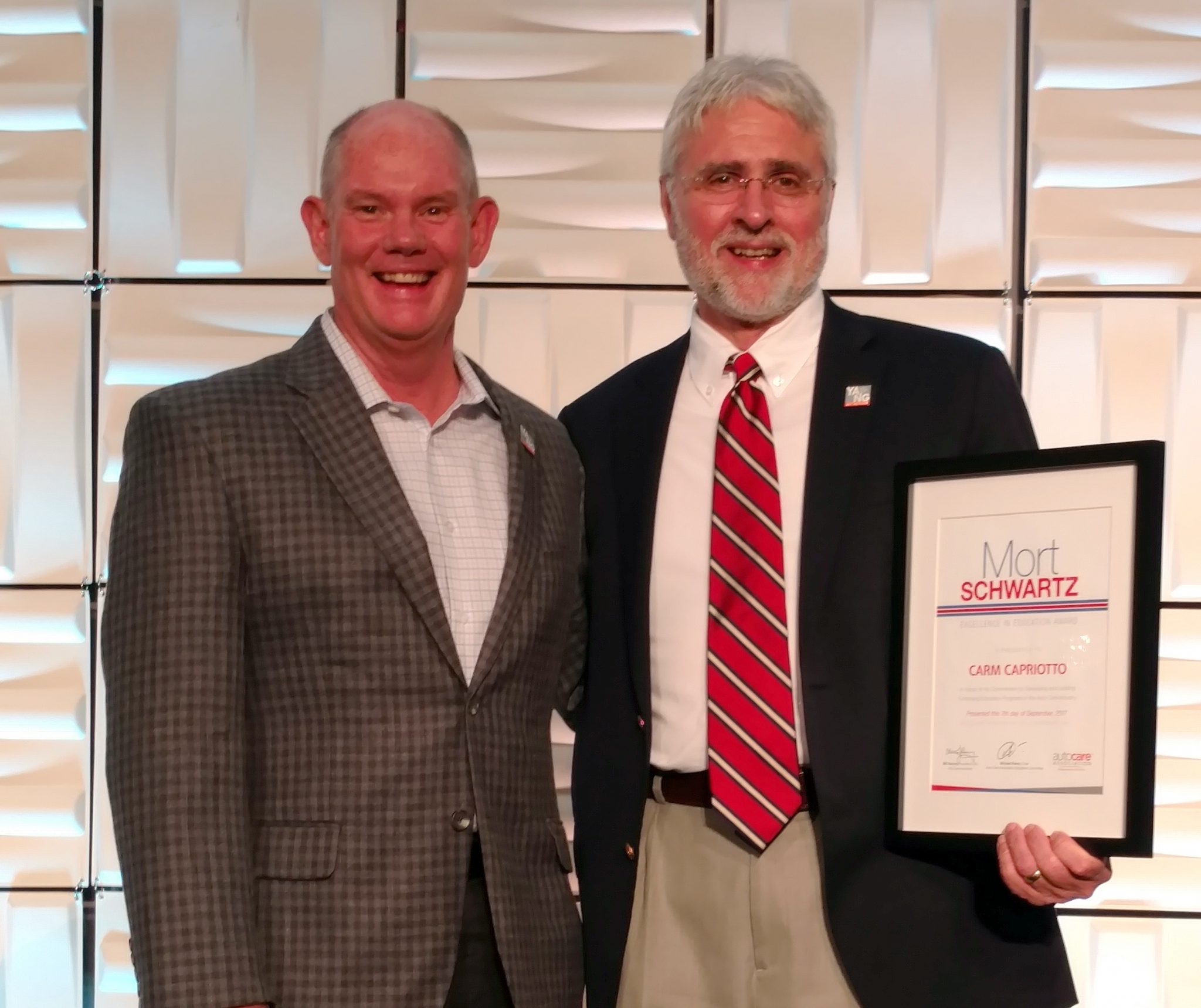 Bill Hanvey, Auto Care Association President and CEO presents Carm Capriotto the 2017 Mort Schwartz Excellence In Education Award